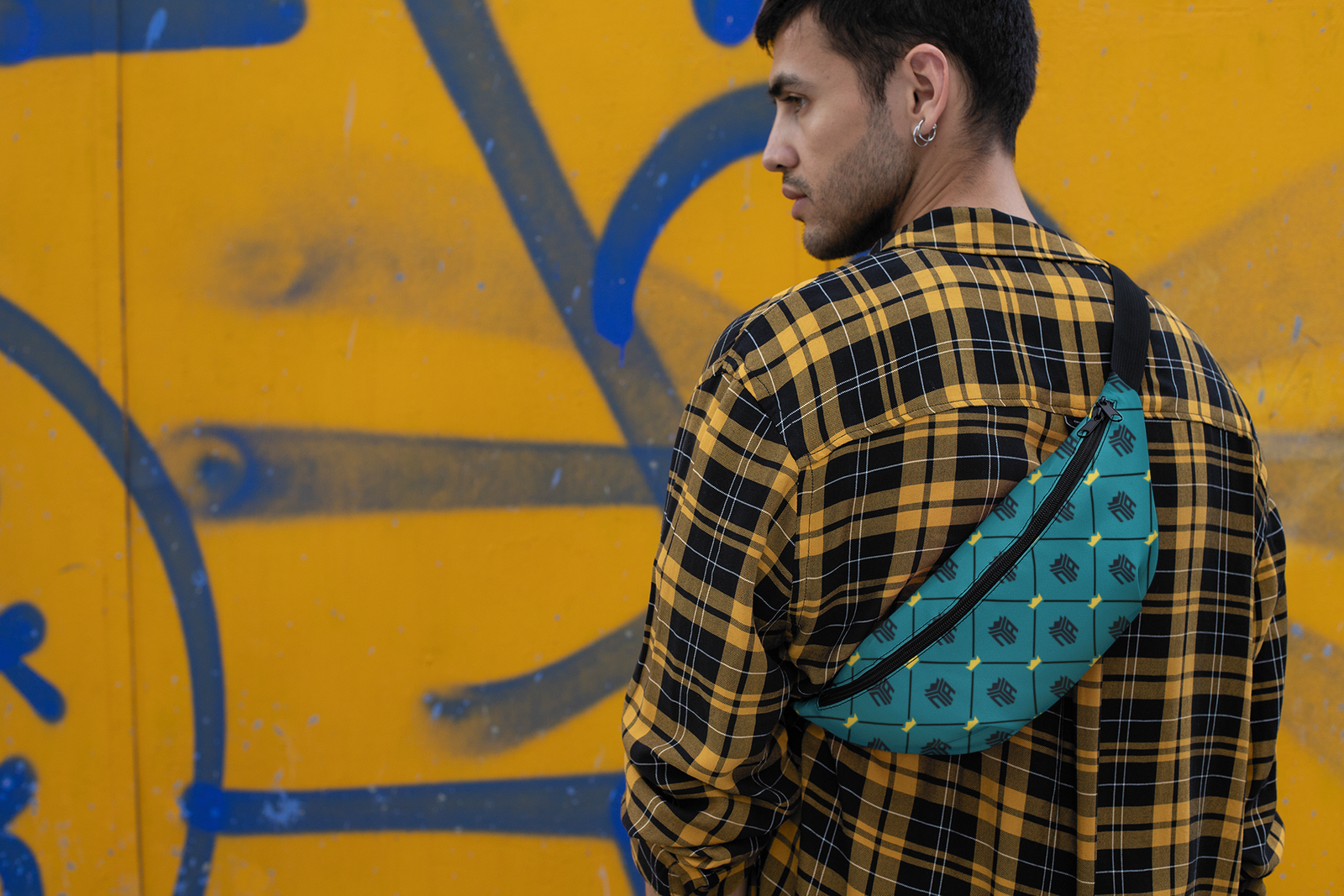 mockup-of-a-man-wearing-a-fanny-pack-facing-a-wall-with-graffiti-29181